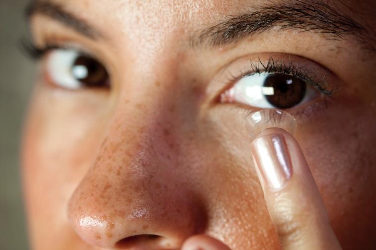 woman putting in a contact lens