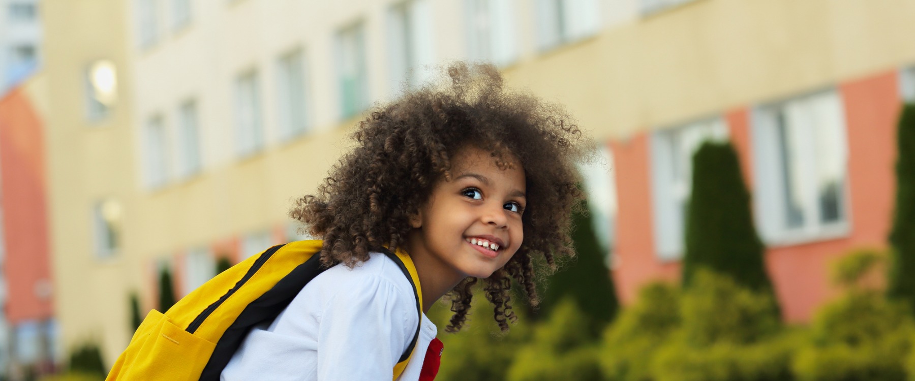 Little girl waiting outdoors of school