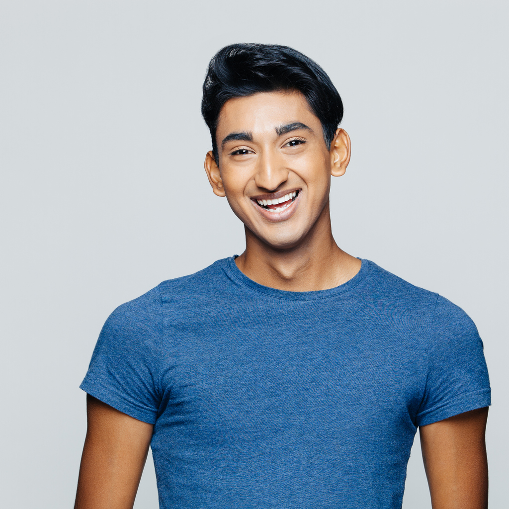 Smiling Young Man In Front A Grey Background 