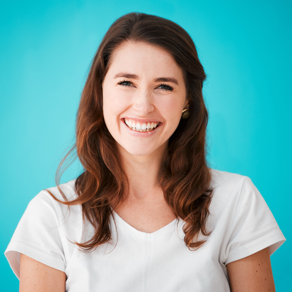 Cropped portrait of an attractive young woman posing in studio against a blue background