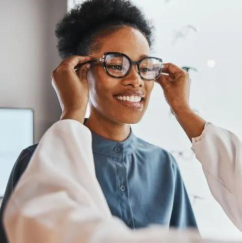 Woman smiling trying on glasses