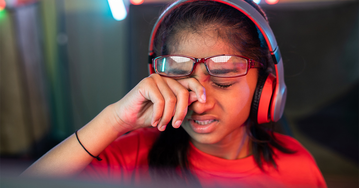 A child rubbing her eye, experiencing eye strain.